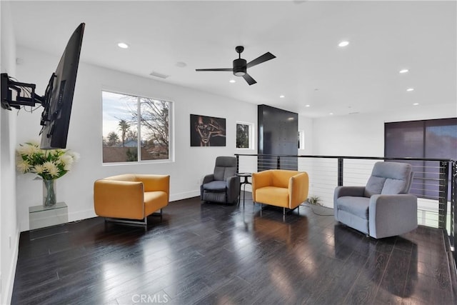 sitting room with dark wood-type flooring and ceiling fan