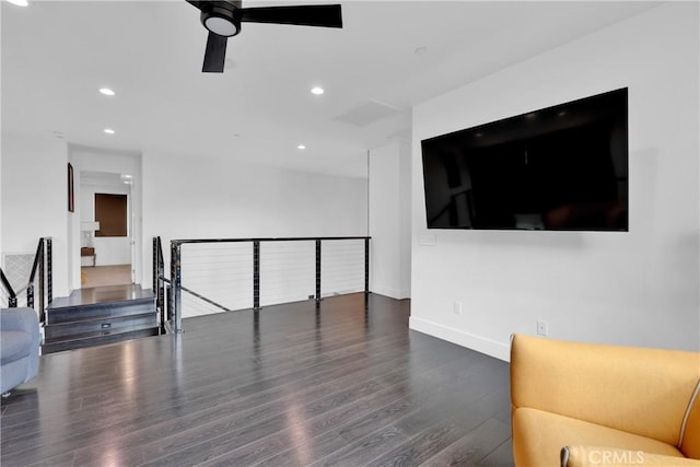 living room featuring ceiling fan and dark hardwood / wood-style flooring