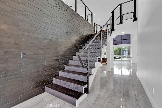 stairs featuring tile patterned flooring and a high ceiling