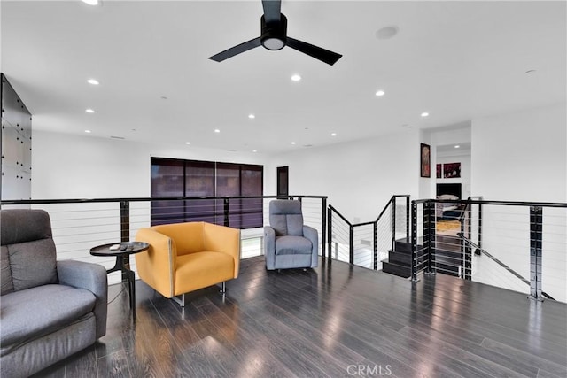 sitting room with ceiling fan and wood-type flooring