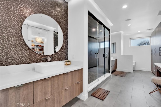 bathroom featuring a shower with door and vanity