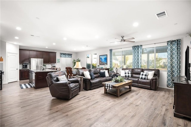 living room featuring ceiling fan and light hardwood / wood-style flooring