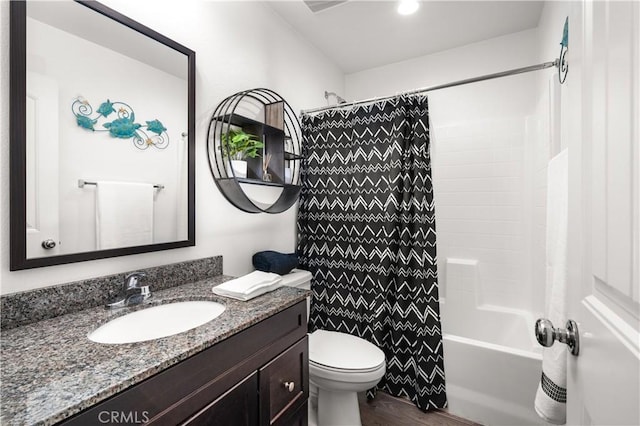 full bathroom with hardwood / wood-style flooring, vanity, shower / tub combo, and toilet