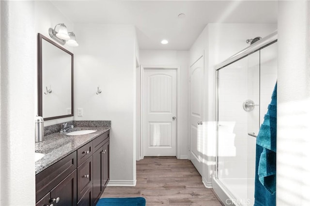 bathroom with a shower with door, vanity, and hardwood / wood-style flooring