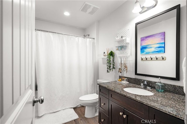 bathroom with vanity, toilet, and hardwood / wood-style floors