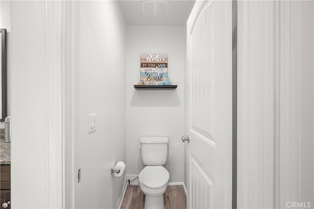 bathroom featuring wood-type flooring and toilet