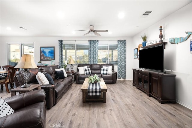 living room featuring light hardwood / wood-style floors and ceiling fan