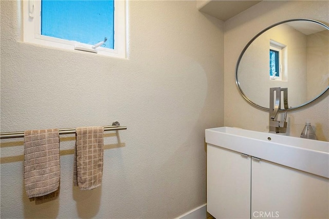 bathroom with vanity and a textured wall