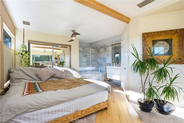 bedroom with beamed ceiling and light hardwood / wood-style floors