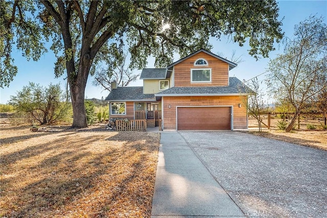 view of front of house featuring driveway, an attached garage, and a shingled roof