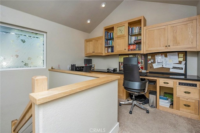 carpeted office space featuring built in study area and vaulted ceiling