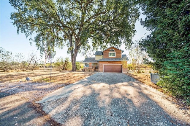 view of front of house with fence, a garage, and driveway