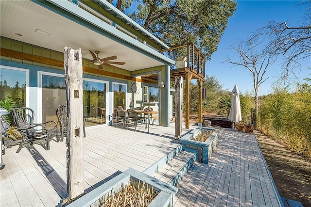 deck featuring outdoor dining space, a jacuzzi, and ceiling fan