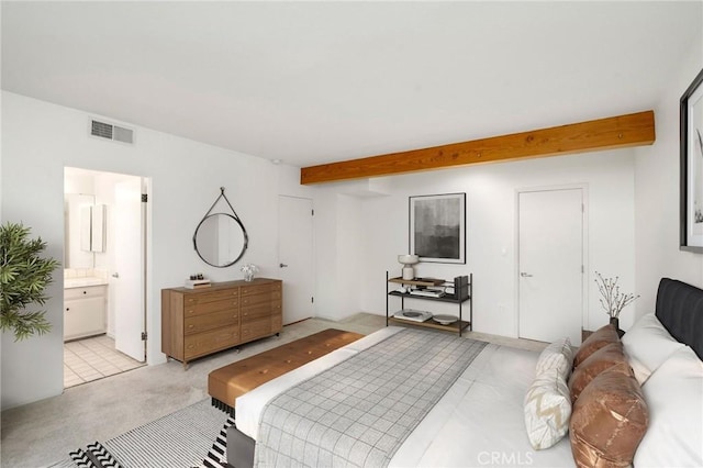 bedroom featuring beamed ceiling and connected bathroom