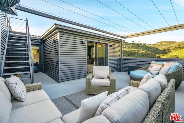 view of patio featuring an outdoor living space and a mountain view