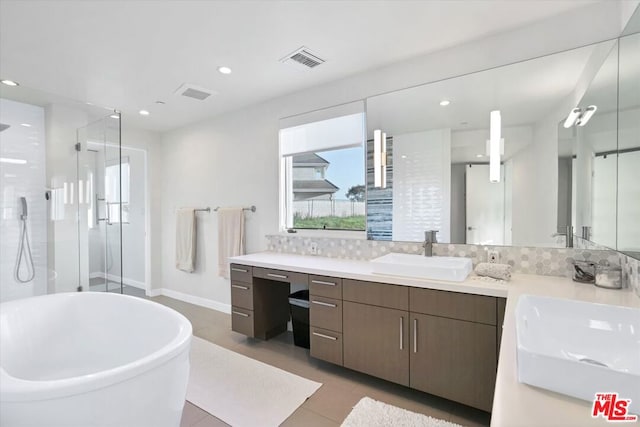 bathroom with tile patterned floors, vanity, backsplash, and plus walk in shower