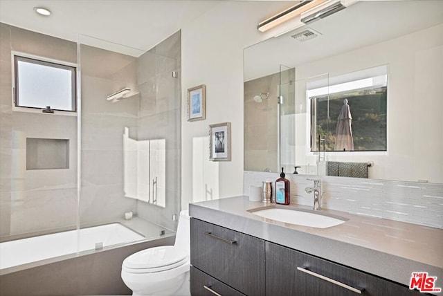 full bathroom featuring vanity, toilet, and enclosed tub / shower combo