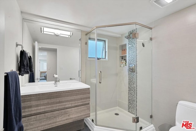 bathroom with vanity, toilet, and walk in shower