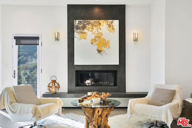 living area with hardwood / wood-style floors and a large fireplace