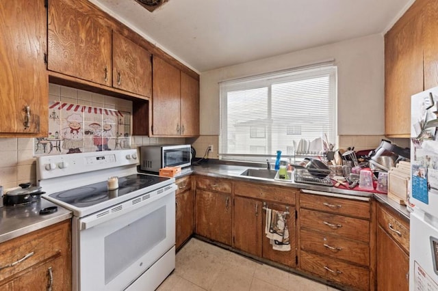 kitchen with light tile patterned floors, white electric stove, backsplash, and fridge