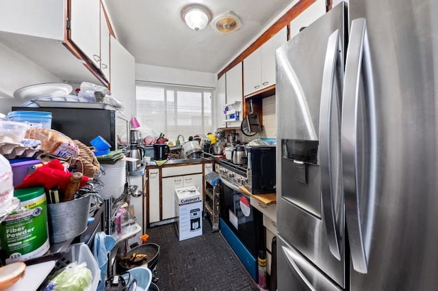 kitchen with stainless steel refrigerator with ice dispenser and white cabinets