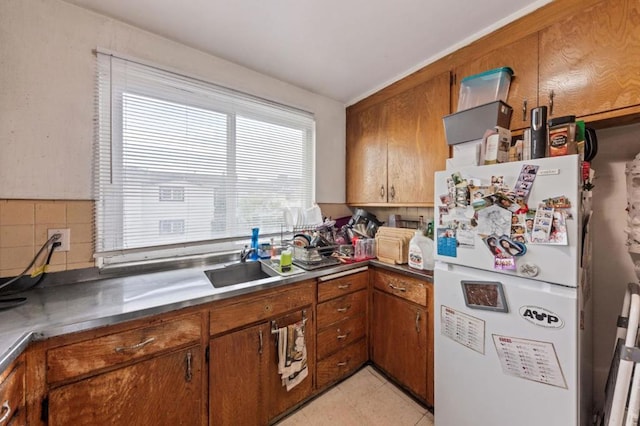 kitchen with sink, backsplash, and white refrigerator