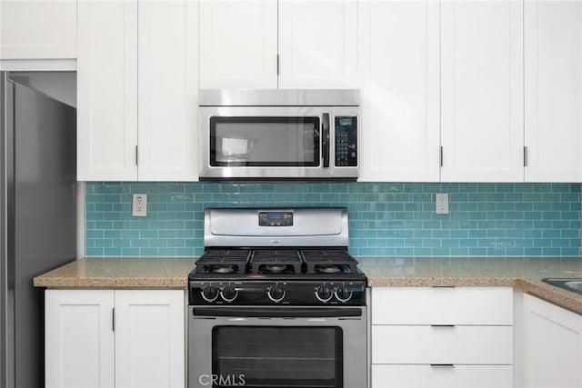 kitchen featuring light stone countertops, white cabinetry, stainless steel appliances, and tasteful backsplash