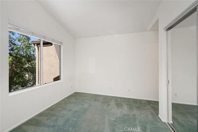 carpeted spare room featuring lofted ceiling