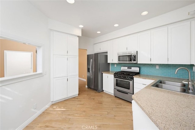 kitchen featuring light hardwood / wood-style flooring, stainless steel appliances, white cabinetry, and sink