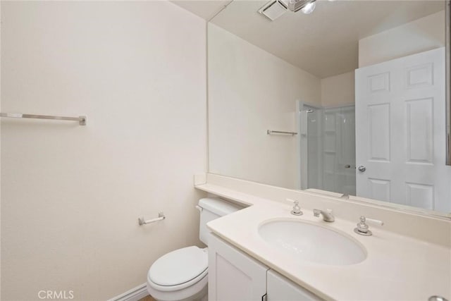 bathroom with vanity, toilet, and a shower