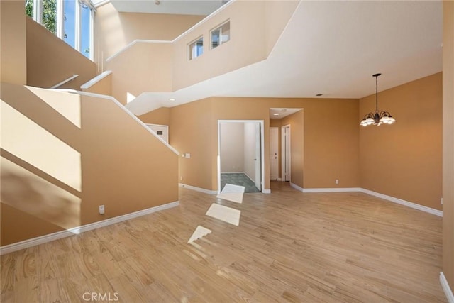 unfurnished living room featuring a notable chandelier and wood-type flooring