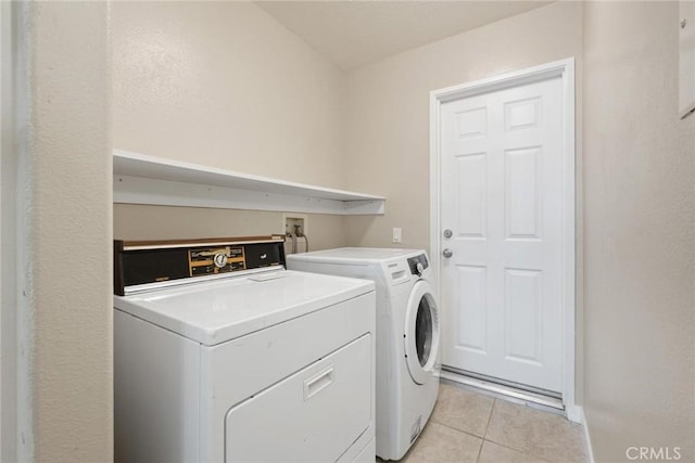 washroom with light tile patterned floors and washer and clothes dryer