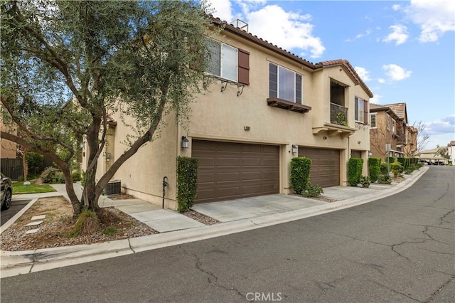 multi unit property featuring central AC, a balcony, and a garage