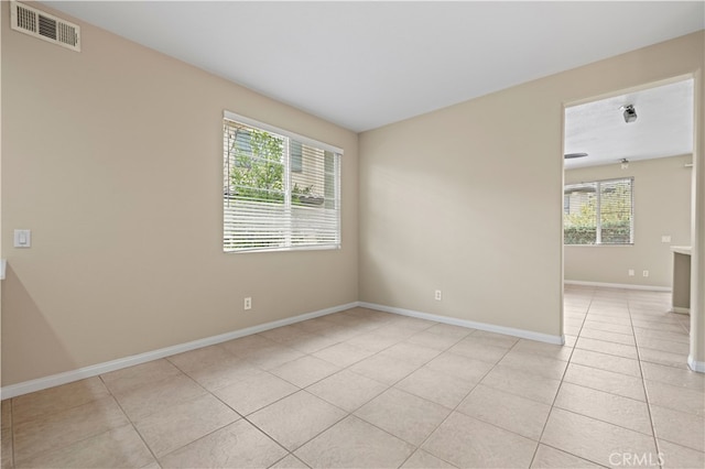 spare room featuring light tile patterned floors and a healthy amount of sunlight