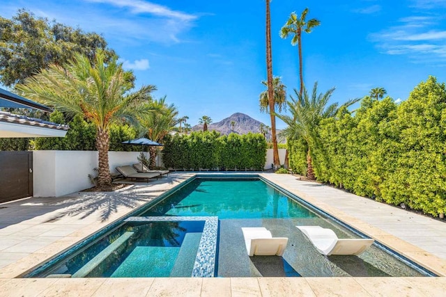 view of pool featuring a mountain view, an in ground hot tub, and a patio