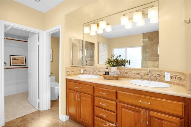 bathroom featuring toilet, tile patterned floors, tasteful backsplash, and vanity