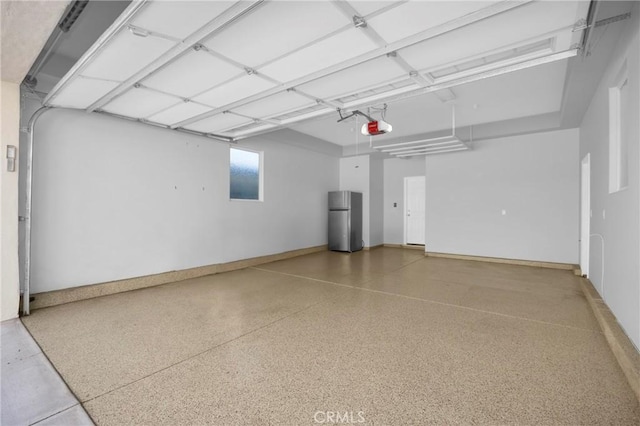 garage featuring a garage door opener and stainless steel fridge