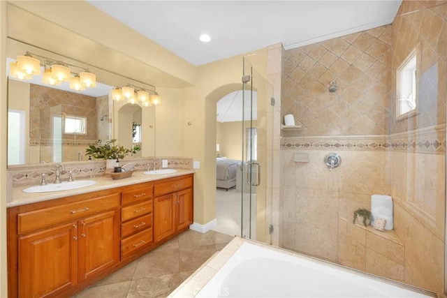 bathroom featuring plus walk in shower, tile patterned flooring, and vanity