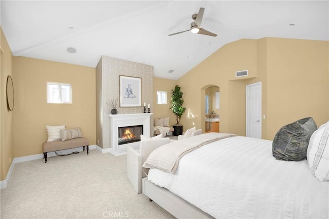 carpeted bedroom featuring ceiling fan, a large fireplace, and lofted ceiling