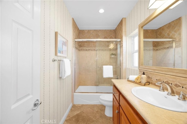 full bathroom featuring toilet, vanity, and shower / bath combination with glass door