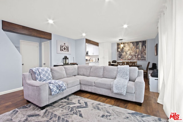 living room featuring dark wood-type flooring and beamed ceiling