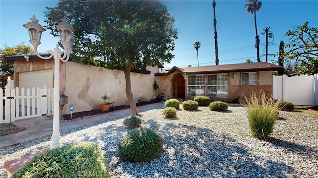 ranch-style home with a gate, fence, and stucco siding