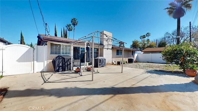 rear view of house with a patio area, central AC unit, fence private yard, and a gate