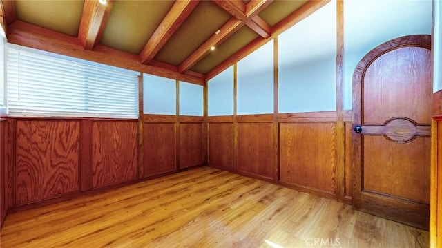 unfurnished sunroom featuring lofted ceiling with beams