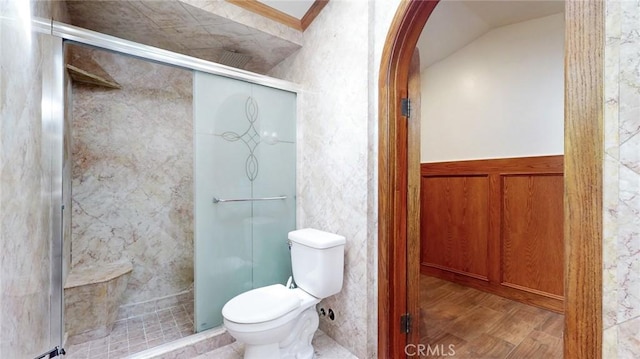 bathroom featuring a stall shower, toilet, and wood finished floors