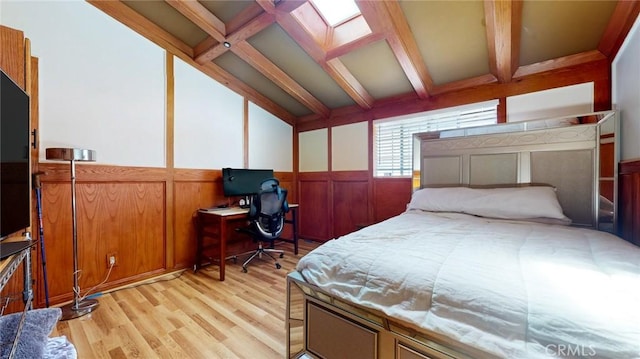 bedroom with vaulted ceiling with beams, wainscoting, and light wood finished floors