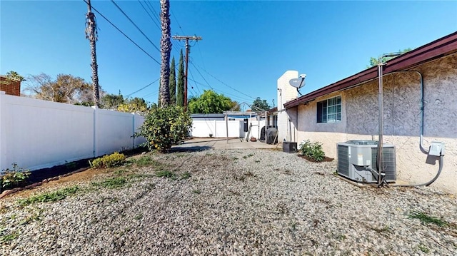 view of yard with central air condition unit, a fenced backyard, and a patio area