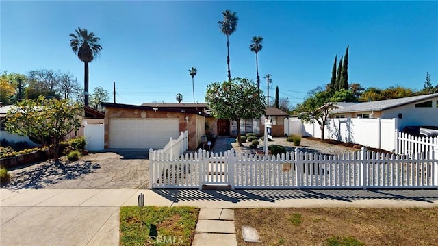 view of front of property featuring a fenced front yard, driveway, and an attached garage