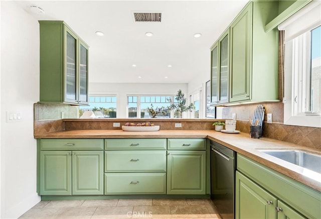 kitchen featuring dishwasher, a wealth of natural light, and green cabinets