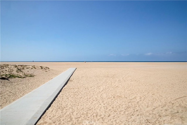 surrounding community featuring a water view and a beach view